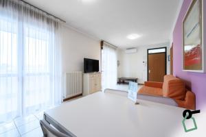 a living room with an orange couch and a tv at HOTIDAY Residence Garda in Peschiera del Garda