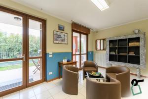 a waiting room with chairs and a table and a tv at HOTIDAY Residence Garda in Peschiera del Garda