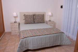 - une chambre avec un grand lit et 2 tables de chevet dans l'établissement Vila Rosal Margarida Apartment, à Albufeira