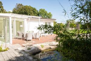 a house with a patio with a pond at Meer Weiss in Wangerland