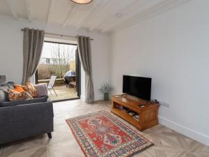 uma sala de estar com uma televisão e um sofá em Rowan Barn em Hexham