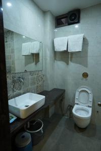 a bathroom with a white toilet and a sink at Hotel Hrushikesh in Shirdi