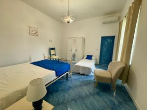 a bedroom with a bed and a chair and a desk at IL PROFUMO DEI FIORI SUITE in Praiano