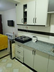a kitchen with white cabinets and a stove in it at Mellow Homes 1 & 2 Bedrooms fully furnished Apartment in Kitengela 