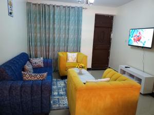 a living room with two couches and a tv at Mellow Homes 1 & 2 Bedrooms fully furnished Apartment in Kitengela 