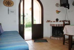a room with a bed and a door and a fireplace at Villetta Bedogni in Simius