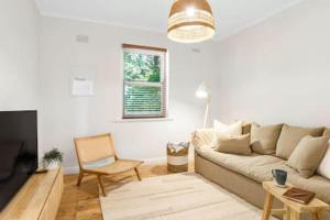 a living room with a couch and a chair at Rossini's Cottage - Hills Escape in Mount Lofty