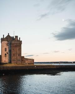 a castle on the shore of a body of water at Castle Beach in Broughty Ferry