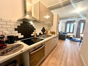 eine Küche mit Herd Top-Backofen neben einem Wohnzimmer in der Unterkunft Le Countryside- hyper centre in Sens