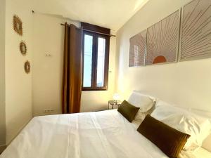 ein weißes Bett in einem Schlafzimmer mit einem Fenster in der Unterkunft Le Countryside- hyper centre in Sens + 5 Fotos