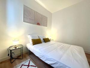 ein Schlafzimmer mit einem großen weißen Bett und einem Tisch in der Unterkunft Le Countryside- hyper centre in Sens