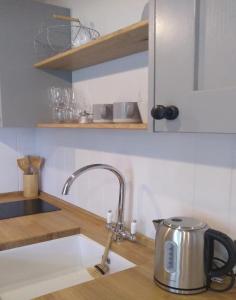 a kitchen sink with a tea kettle on a counter at Finest Retreats - The Bakers Hut in Ashurst