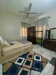 sypialnia z łóżkiem i wentylatorem sufitowym w obiekcie 192 homestay w mieście Alor Setar