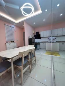 a kitchen with a table and chairs in a room at Eighty2 House Palmyra Residence in Bangi