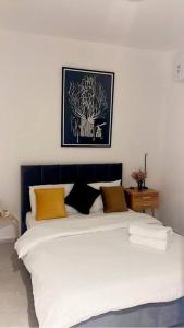 een slaapkamer met een groot wit bed met gele kussens bij amazing florentin flat 6 in Tel Aviv
