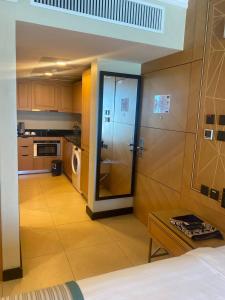 a room with a kitchen with a refrigerator at Nooh Apartment in Al Ḩadd