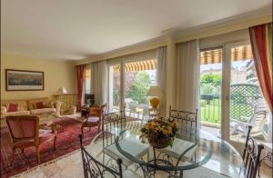 a living room with a glass table and chairs at Cosy T3 - Jardin - Parking - Piscine in Montpellier