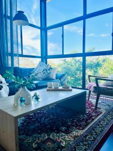 Rylstonethe little nest, Rylstone的客厅配有一张咖啡桌,位于大窗户前