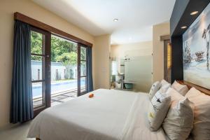 a bedroom with a large bed and a large window at Enigma Villa Canggu in Canggu