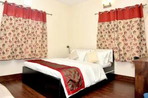 a bedroom with a bed with red curtains at Orchid B&B in Kolkata