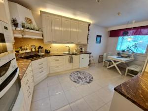 a kitchen with white cabinets and a sink and a window at Mindfulness Homestay in Espoo in Espoo