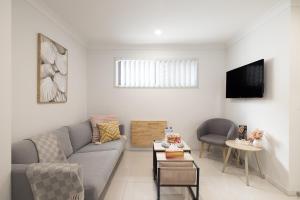 a living room with a couch and a tv at Air Con! Laundry! Stylish! in Brisbane