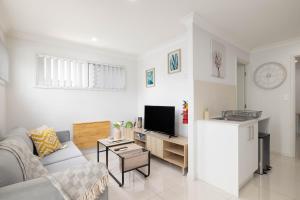 a living room with a couch and a tv at Aircon! Parking! Host with 100s of 5 star Reviews! in Brisbane