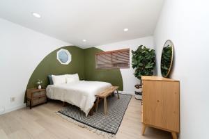a bedroom with a bed and a green wall at Downtown Beach Home, 5 min to Beach! Backyard, BBQ in Huntington Beach