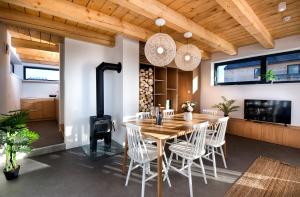 Natur Views, Chaty NATUR RESORT في فيلكا لومنيكا: غرفة طعام مع طاولة وموقد خشبي