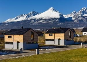 Natur Views, Chaty NATUR RESORT في فيلكا لومنيكا: بيتين أمام جبل مغطى بالثلج