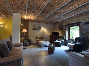una sala de estar con sofás y una pared de piedra. en Holiday home in the heart of the Ardennes, en Libramont