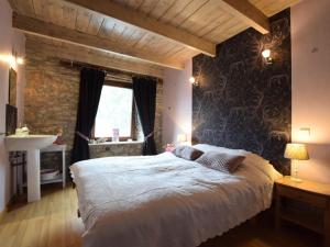 sypialnia z dużym łóżkiem i kamienną ścianą w obiekcie Holiday home in the heart of the Ardennes w mieście Libramont
