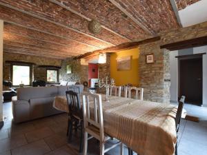 een eetkamer met een tafel en een bakstenen muur bij Holiday home in the heart of the Ardennes in Libramont