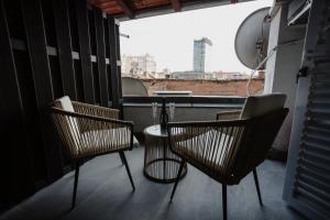 3 sillas y una mesa en un balcón con vistas en AMORE LUXURY APARTMENT en Zagreb