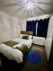 1 Schlafzimmer mit 2 Betten, einem Kronleuchter und einem blauen Teppich in der Unterkunft Modern & Cozy 3 Bed House. in Wyken