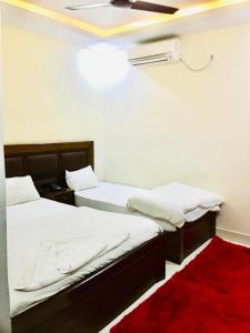 two beds in a room with a red rug at Hotel Suramma Pvt. Ltd. in Rummindei