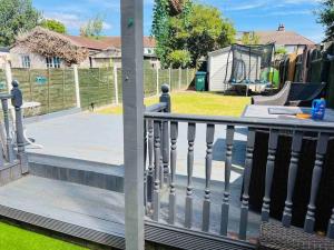 une terrasse couverte avec une clôture et une aire de jeux dans l'établissement Modern & Cozy 3 Bed House., à Wyken