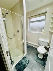 La salle de bains est pourvue d'une douche et de toilettes. dans l'établissement Modern & Cozy 3 Bed House., à Wyken