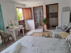 een woonkamer met een bed en een keuken bij Watercolour Cottage in Hermanus