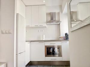 a kitchen with white cabinets and a fireplace at App Coral con AA y Wi-Fi en Vinaròs cerca del mar in Vinaròs