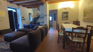 ein Wohnzimmer mit einem Sofa, einem Tisch und Stühlen in der Unterkunft Gnazzano Home 2 in Loiano