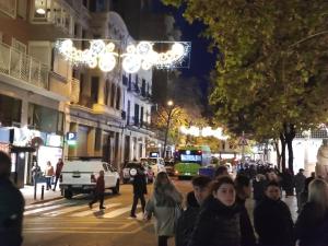 a crowd of people walking down a street at night at ArtStudio Single in Manresa