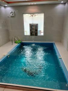 una piscina en una habitación con agua azul en منتجع الكناري للفلل الفندقية الفاخرة Canary resort en Taif