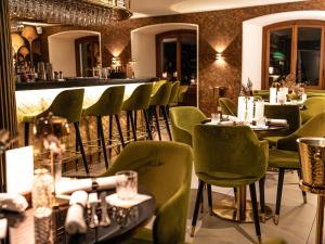 a restaurant with green chairs and a bar at Hotel Porto Sofie Gottlieben in Gottlieben