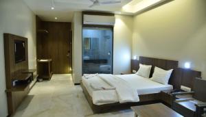 a bedroom with a large bed and a living room at Hotel Hrushikesh in Shirdi