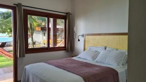 a bedroom with a bed with a view of the ocean at Kaapalua in Porto De Galinhas