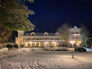 a large building in the snow at night at Hotel Residenz in Heringsdorf