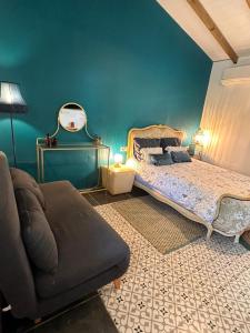 a bedroom with a bed and a couch in it at Le Poppy Palm in Sainte-Luce