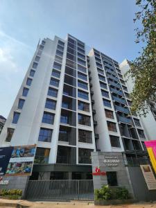 ein hohes weißes Gebäude mit Fenstern auf einer Straße in der Unterkunft Z Bliss Suites, BKC in Mumbai