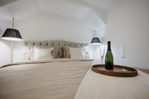 1 dormitorio con 1 cama y 1 botella de vino en la mesa en AMORE LUXURY APARTMENT, en Zagreb